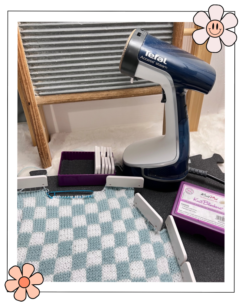 tefal hand steamer shown with knit pro knit blockers and a blue and white knitted fabric pinned out ready to steam block