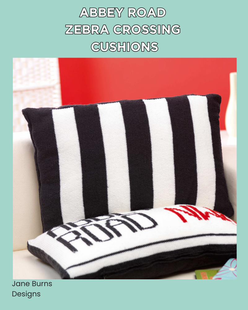 Free Beatles Abbey Road Cushion Knitting Pattern, Two knitted cushion covers on a white sofa — Abbey Road NW8 street sign cushion in black, white and red, alongside a black and white striped zebra crossing cushion, knitting pattern by Jane Burns