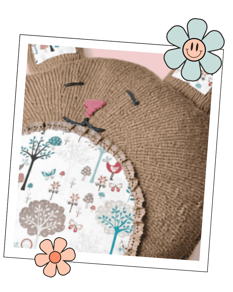 Close up of knitted bunny cushion face, embroidered features and fabric lined ears, Dandelion rabbit cushion pattern jane burns 