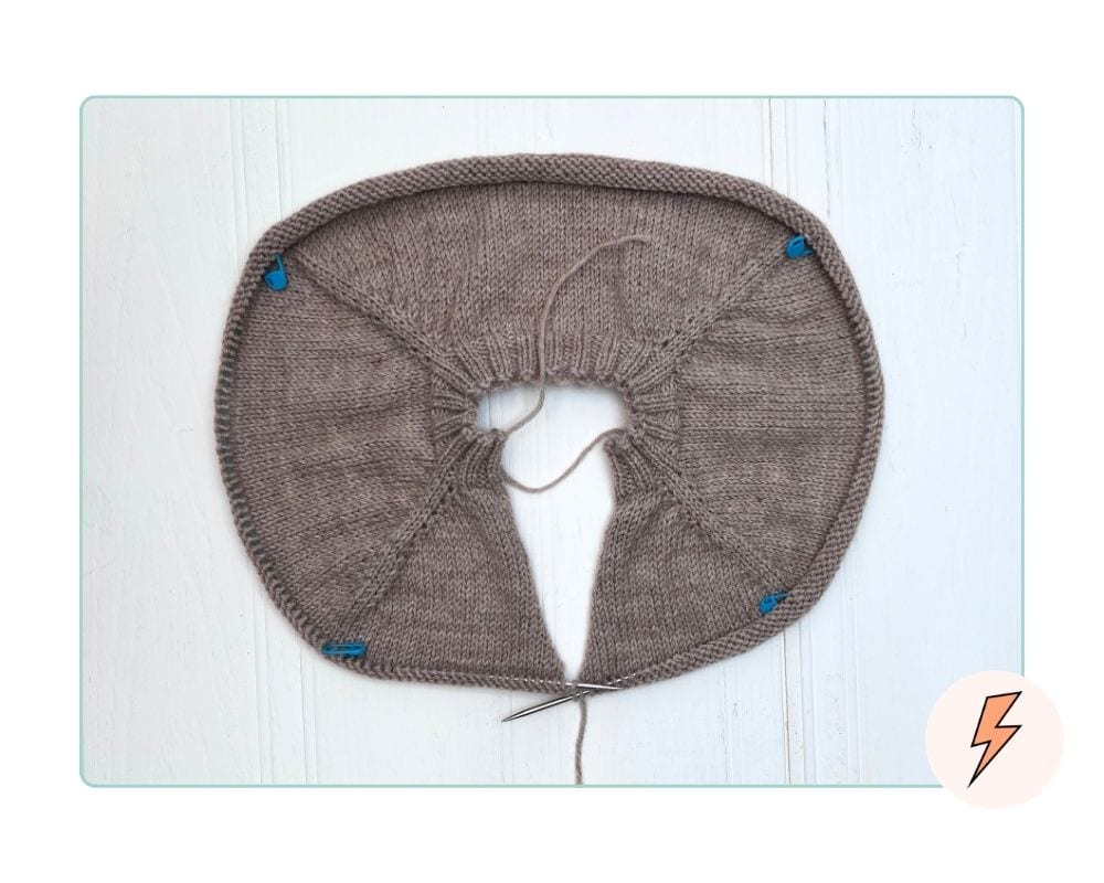 Top-down children's cardigan laid flat showing raglan lines developing in the yoke, before sleeve separation how-to-knit-a-top-down-cardigan-for-kids