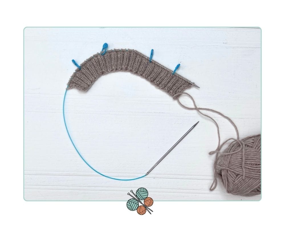 Four stitch markers placed at raglan positions on a top-down children's cardigan, wrong side facing how-to-knit-a-top-down-cardigan-for-kids