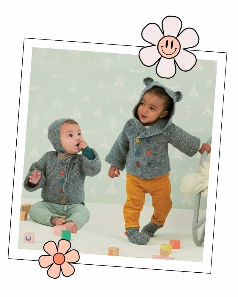 Two toddlers wearing matching grey knitted cardigans with garter stitch baby booties
