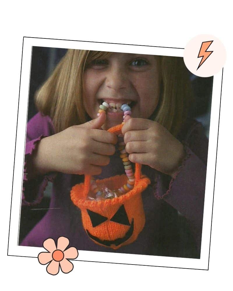 blonde child holding orange knitted halloween pumpkin bag, free knitting pattern for children
