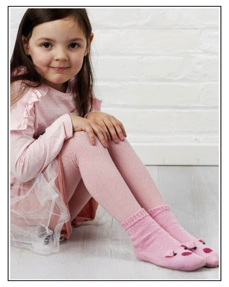 pig socks knitting pattern for kids, pink hand knitted socks with pig faces on the toes.